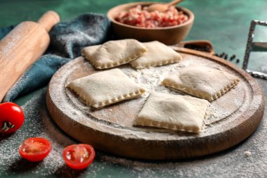 Masada çiğ ravioli ile ahşap tahta.