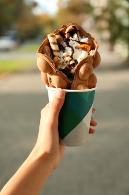 Fincan lezzetli tatlı kabarcık gözleme ile açık havada tutan kadın