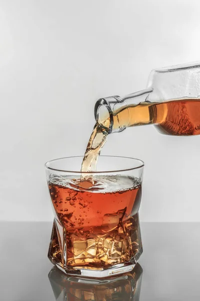 Gieten Van Whisky Uit Fles Het Glas Witte Achtergrond — Stockfoto