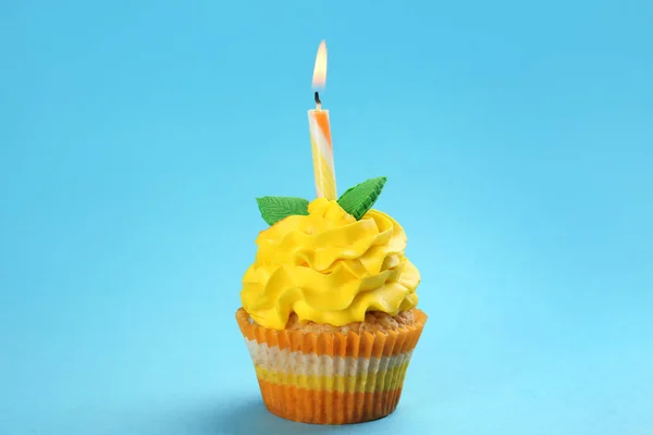 色の背景に燃えるろうそくとおいしい誕生日カップケーキ — ストック写真