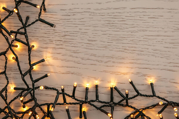 Glowing Christmas lights on wooden table