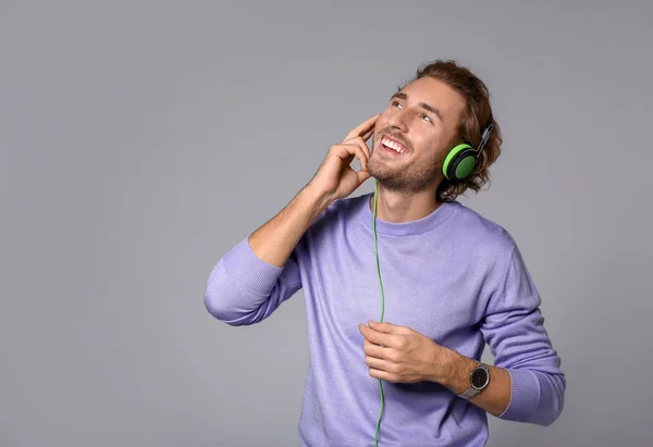Jonge Man Luisteren Naar Muziek Een Grijze Achtergrond — Stockfoto