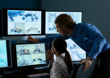 Security guards monitoring modern CCTV cameras in surveillance room clipart