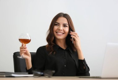 Güzel genç kadın ofiste şarap içme