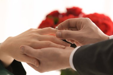 Koyarak nişan yüzüğünü nişanlısının parmağına genç adam