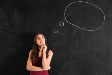 Düşünceli genç kadının yanına tahtaya çizilen boş konuşma balonu