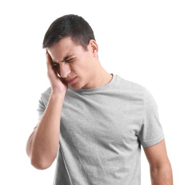 Beyaz arka planda baş ağrısı çeken genç bir adam.
