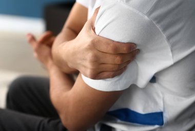 Genç adam closeup kol evde, acı acı