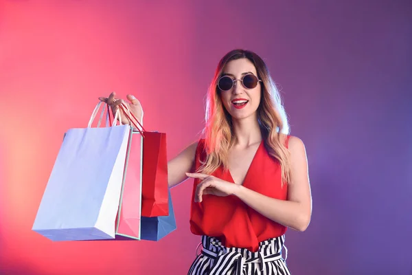 Schöne Junge Frau Mit Einkaufstaschen Auf Farbigem Hintergrund — Stockfoto