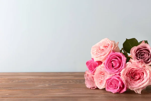 Όμορφη Ανθοδέσμη Τριαντάφυλλα Ξύλινο Τραπέζι Ενάντια Ανοιχτόχρωμο Φόντο — Φωτογραφία Αρχείου