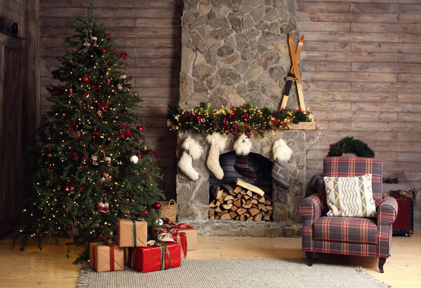 Stylish interior of room with beautiful Christmas tree and fireplace