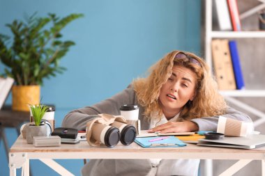 Yorgun genç iş kadını ofiste masa