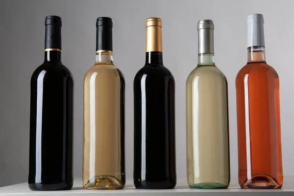 Botellas Con Diferentes Tipos Vino Sobre Fondo Gris — Foto de Stock