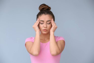 Kadın renk arka plan üzerinde baş ağrısı muzdarip