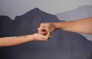 Gri arka plan üzerinde elele kadın ve erkek. Kavramı destek ve yardım