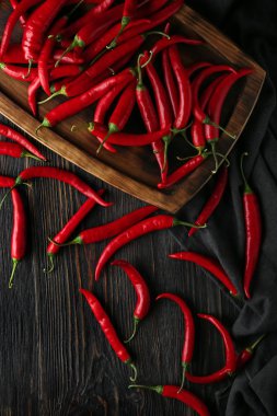 Ahşap masa üzerinde kırmızı sıcak biber ile plaka