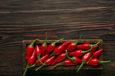 Ahşap masa üzerinde kırmızı sıcak biber ile plaka