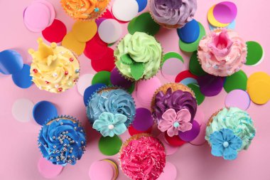 Renk arka plan üzerinde konfeti ile lezzetli cupcakes
