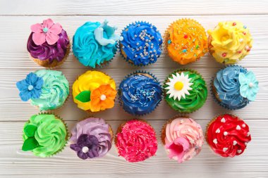 Beyaz ahşap arka plan üzerinde renkli lezzetli kekler kompozisyon