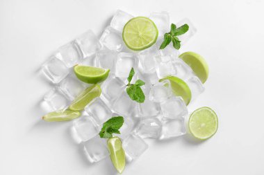 Taze olgun kireç ve buz küpleri beyaz zemin üzerine dilimlenmiş.