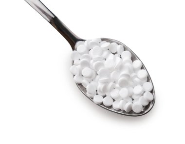 Beyaz arka plan üzerinde stevia haplarla metal kaşık