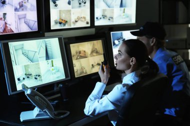 Güvenlik görevlileri gözetleme odasındaki kameraları izliyorlar.