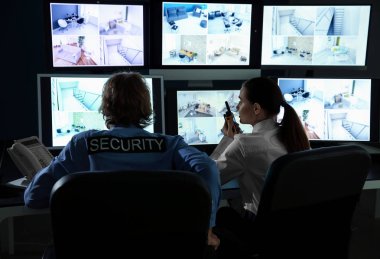 Güvenlik görevlileri gözetleme odasındaki kameraları izliyorlar.