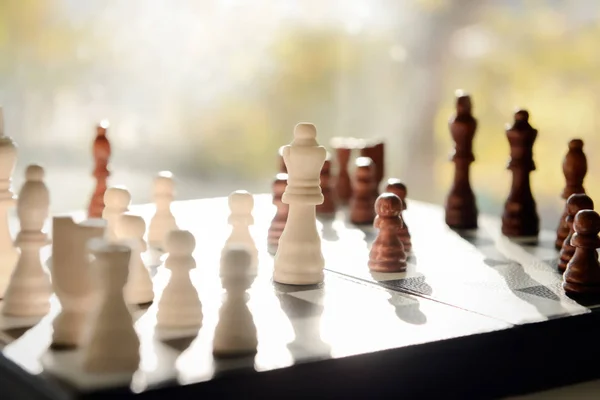 Game board with chess pieces on blurred background