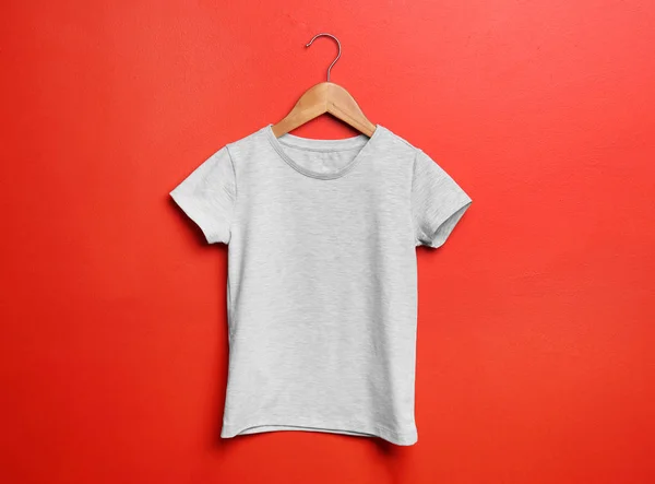 Child t-shirt with hanger on color background