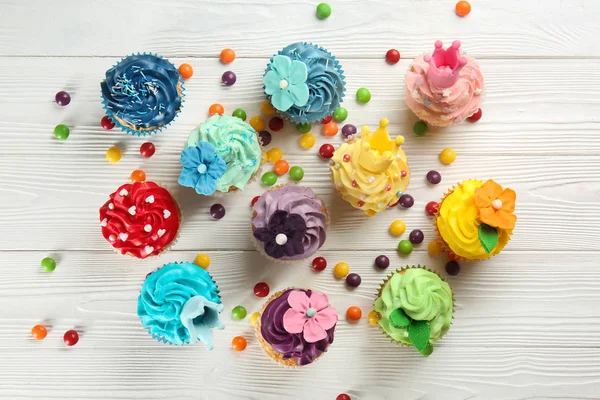 Komposition Mit Köstlichen Bunten Cupcakes Und Bonbons Auf Weißem Holzhintergrund — Stockfoto