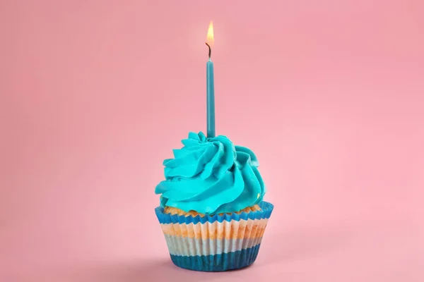 色の背景に燃えるろうそくとおいしい誕生日カップケーキ — ストック写真