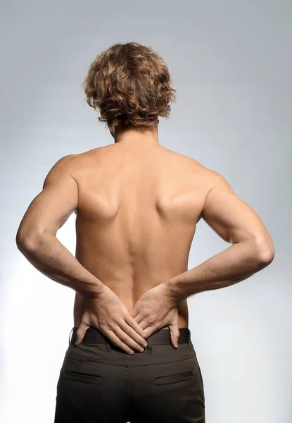 背痛的年轻人 背痛的背景较轻 — 图库照片