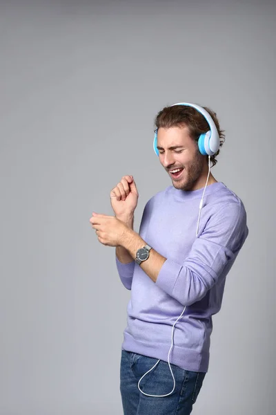 Young Man Listening Music Grey Background — Stock Photo, Image