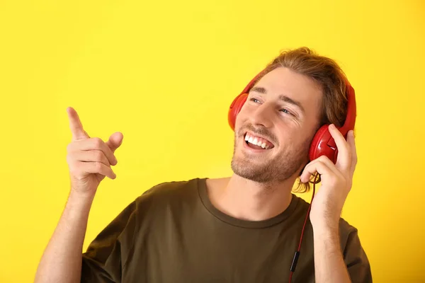 Joven Escuchando Música Sobre Fondo Color —  Fotos de Stock