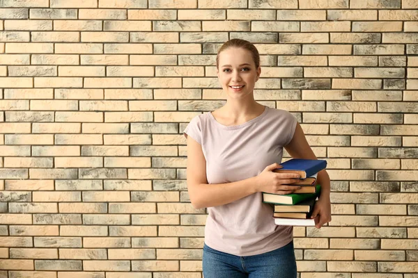 Studentin Mit Bücherstapel Nahe Ziegelmauer — Stockfoto