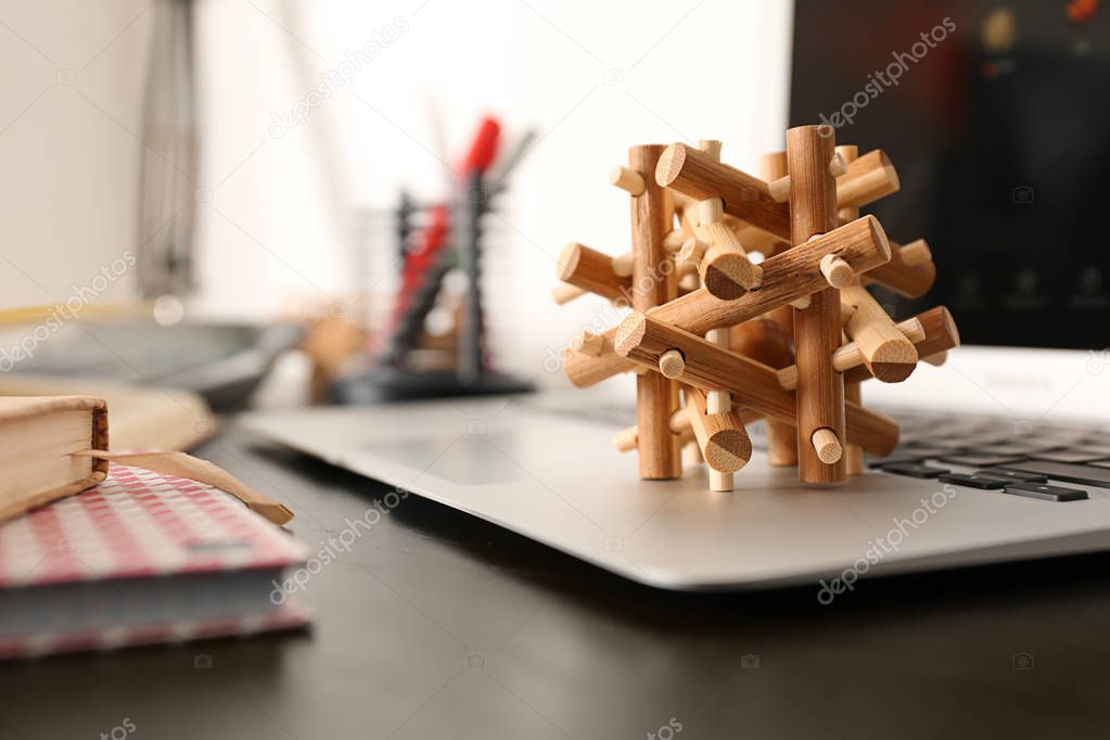 Wooden puzzle on laptop keyboard