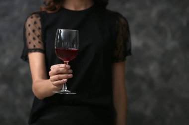 Şarap koyu arka plan üzerinde olan güzel kadın