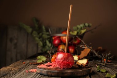 Ahşap masa üzerinde kırmızı şeker elma