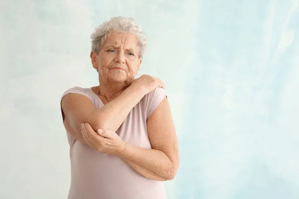 Seniorin Leidet Unter Schmerzen Ellbogen Vor Hellem Hintergrund — Stockfoto