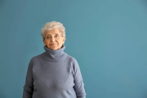 Portrait of senior woman on color background