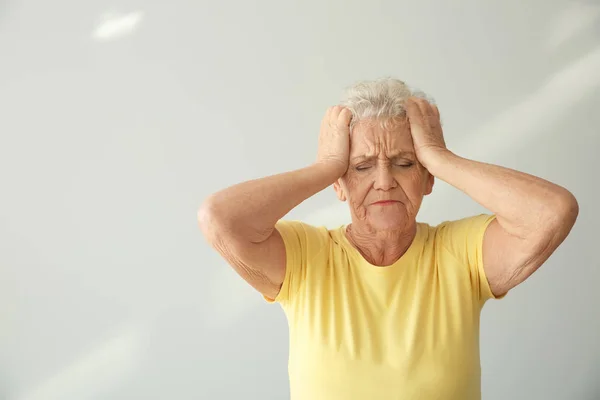 Senior Woman Suffering Headache Light Background — Stock Photo, Image