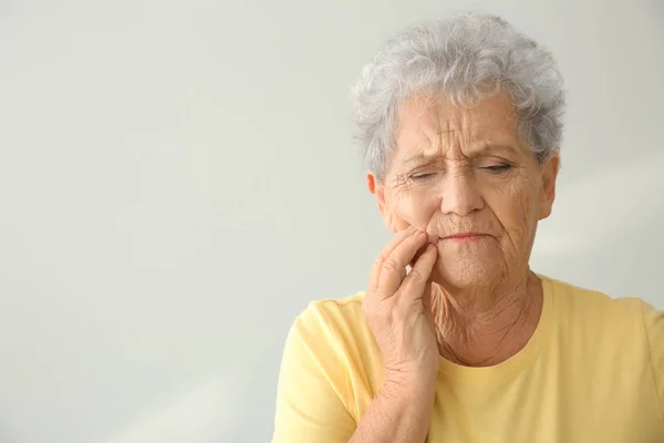 Senior Woman Suffering Toothache Light Background — Stock Photo, Image