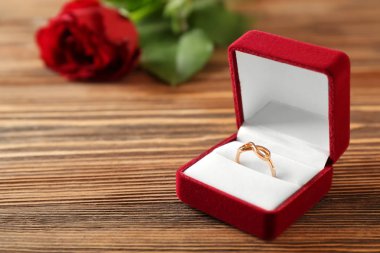 Ahşap masa üzerinde nişan yüzüğü ile açık kutu