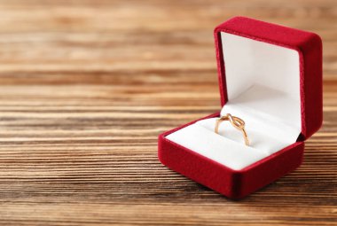 Ahşap masa üzerinde nişan yüzüğü ile açık kutu