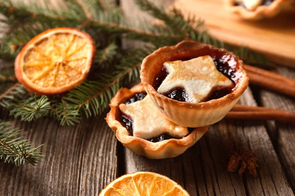 Delicious tarts with jam on wooden table