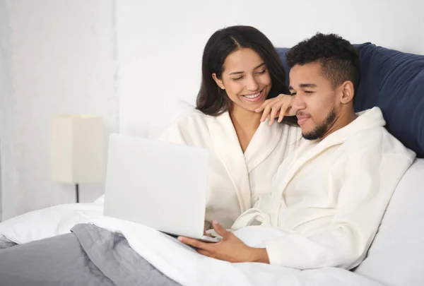 若いカップルはベッドで休んでノート パソコン — ストック写真