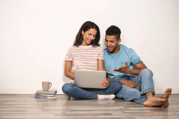 Pareja Joven Con Portátil Sentado Suelo Cerca Pared Luz — Foto de Stock