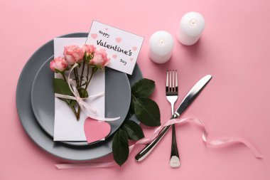 Güzel güller ve renk arka plan üzerinde çatal ile plakalar. Sevgililer günü kutlama