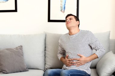 Genç adam evde karın ağrısı acı