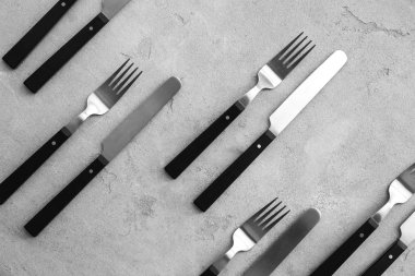 Bıçak ve çatal, düz gri arka plan üzerinde yatıyordu